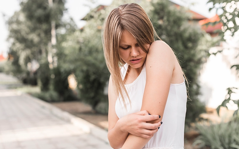Close-up of young woman having pain in elbow